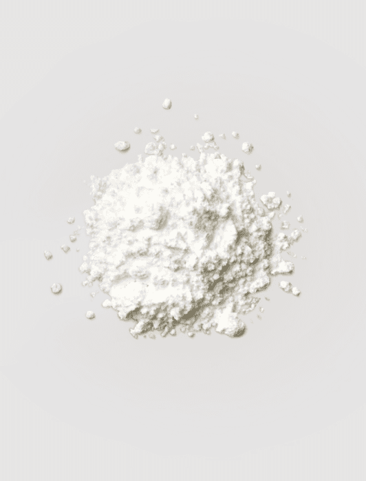 A pile of white powder on a plain gray background.