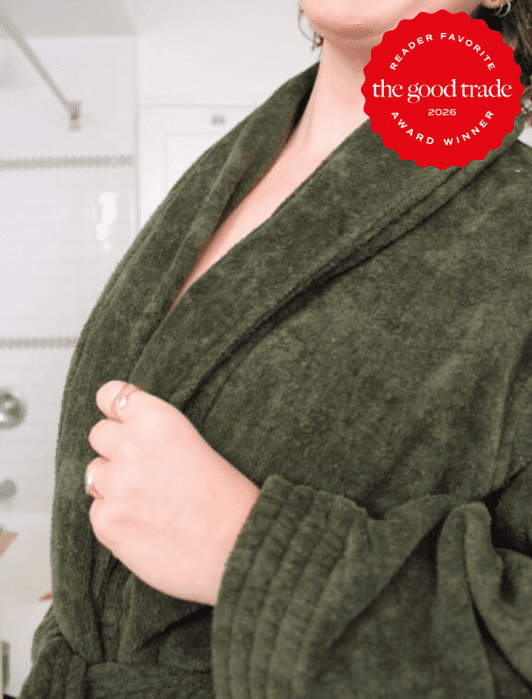 Person wearing an olive green bathrobe stands in a bathroom; a red badge in the corner reads "the good trade 2026 award winner, reader favorite.