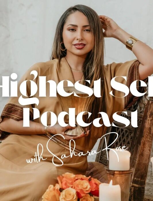 A woman in a tan dress sits on a wooden chair with candles and flowers in front of her. Text reads “Highest Self Podcast with Sahara Rose.”.