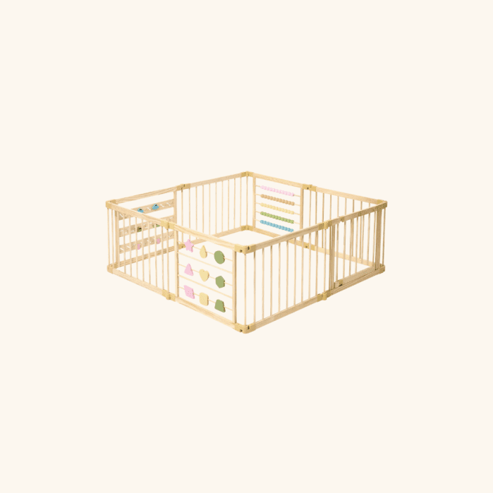 Wooden baby playpen with light-colored bars, featuring built-in activity panels including shapes, beads, and an abacus, placed on a plain light background.