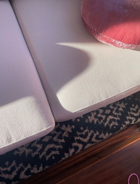Close up of the cushion of a white burrow couch.