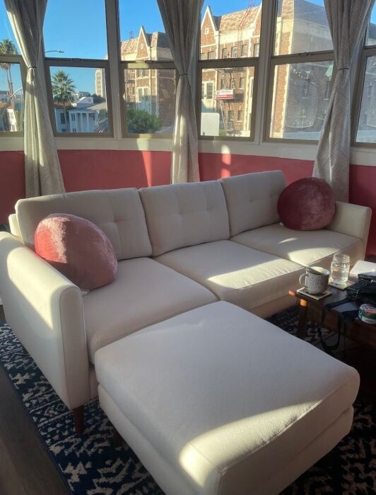 A white Burrow couch in a pink living room.