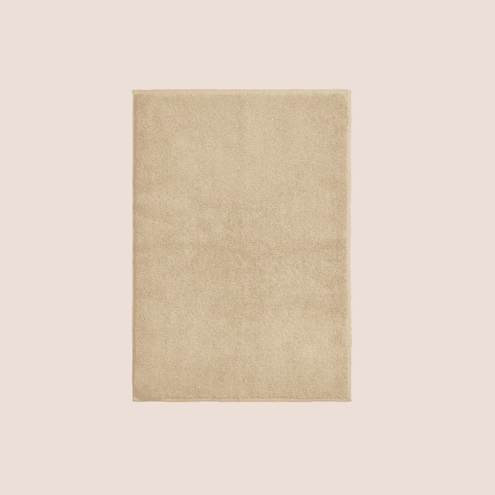 Rectangular beige rug with a soft, plush texture displayed on a light background.