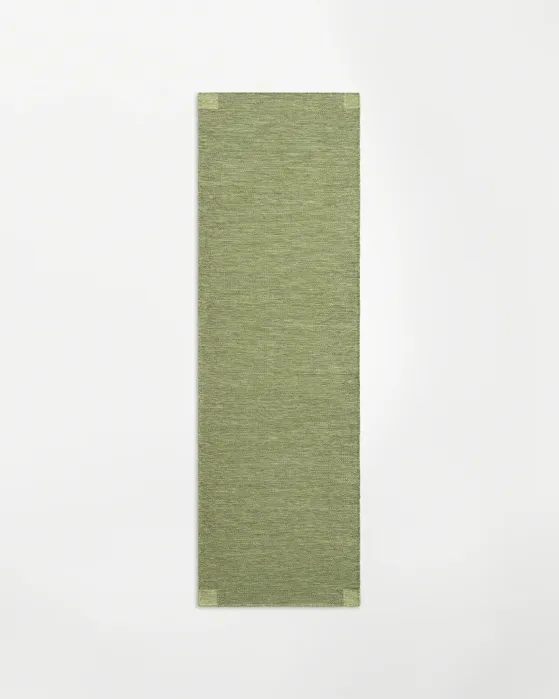 Rectangular sage green runner rug with a subtle textured weave.