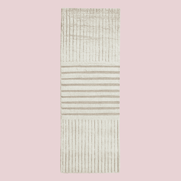 Rectangular area rug with alternating sections of vertical and horizontal stripes in cream and beige.