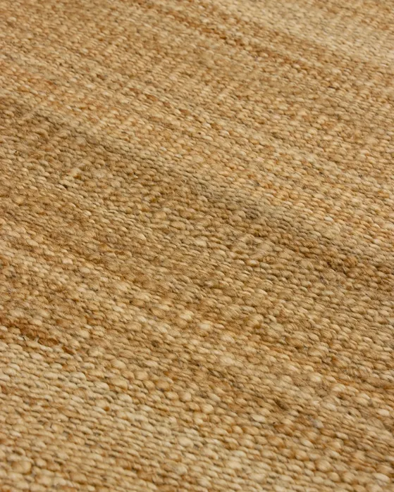 Close-up of a tan woven natural fiber rug.