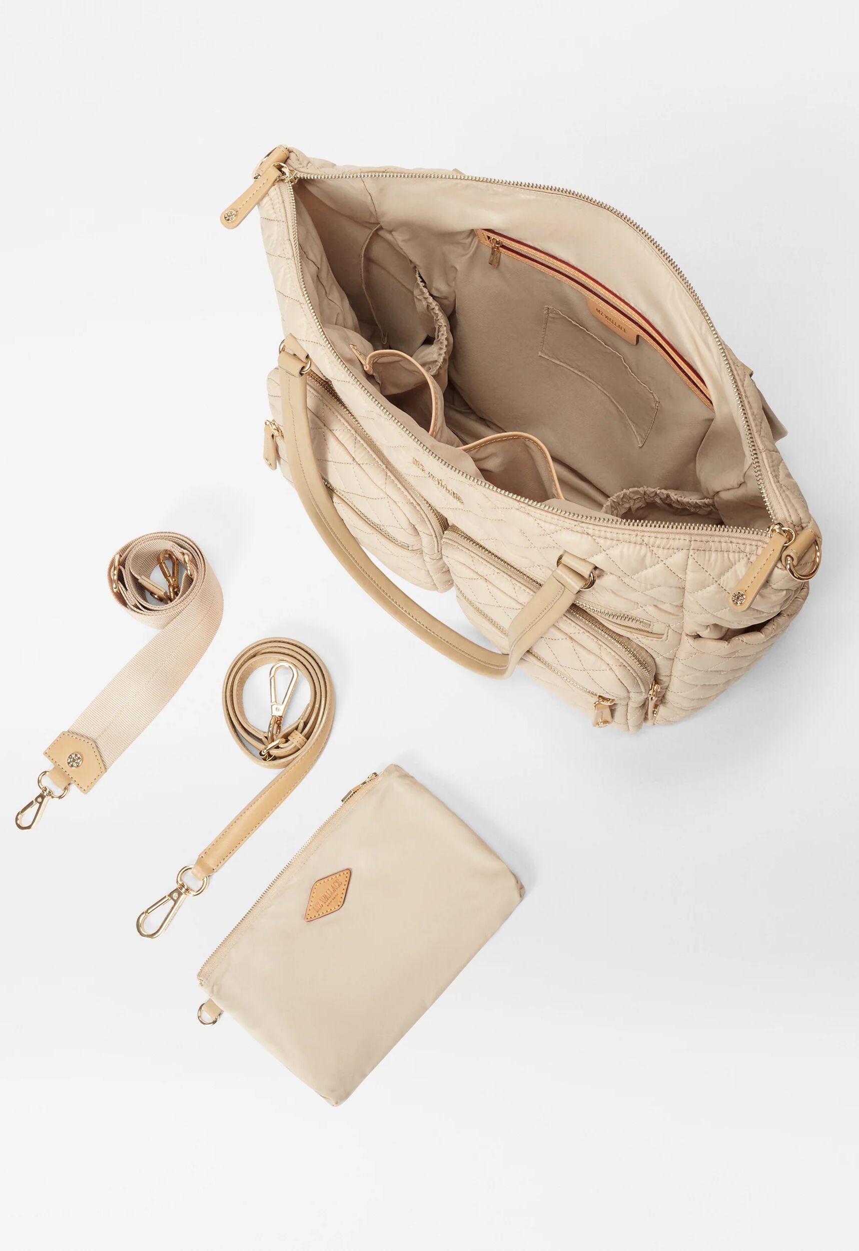 Beige quilted diaper bag with an open interior, a matching zippered pouch, and two detachable shoulder straps.
