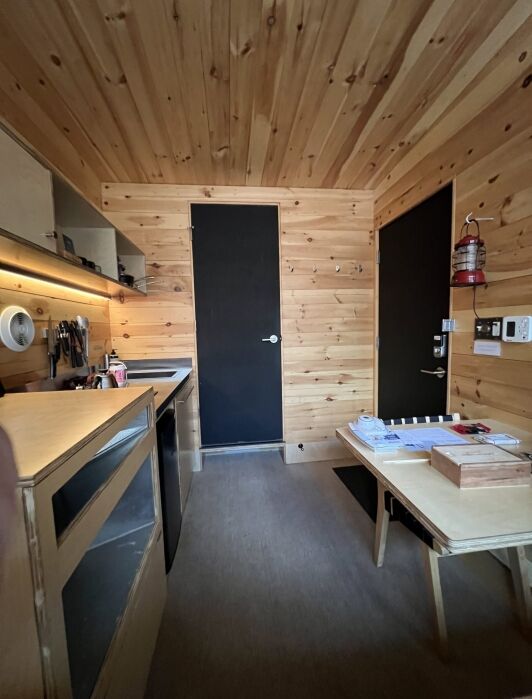 A small kitchen in a wood-paneled room.