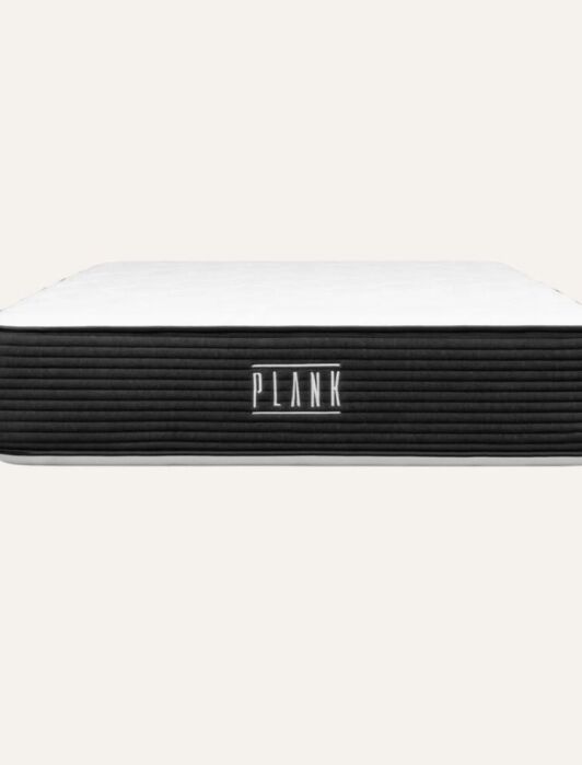 A rectangular mattress with a black and white design, featuring the word "plank" in bold letters on the front.