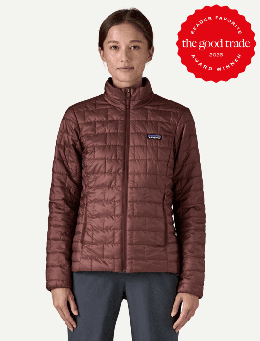 A woman wearing a maroon quilted jacket stands facing forward. A red badge in the corner reads "The Good Trade Award Winner 2026 Reader Favorite.