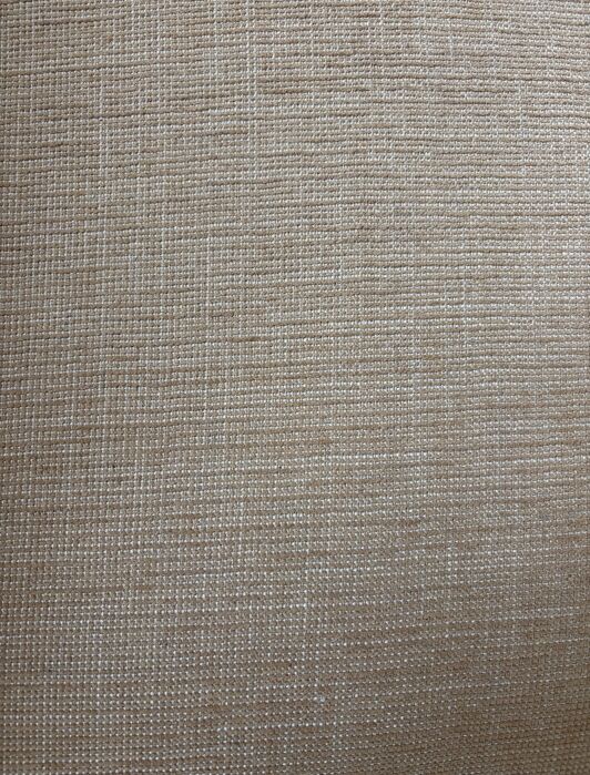 Close-up view of beige woven fabric with a visible textured pattern of intersecting threads.