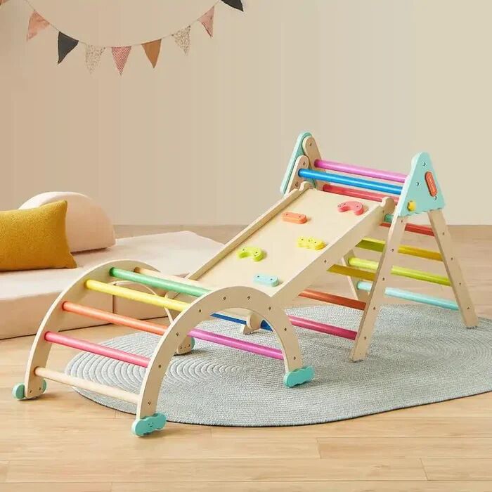 Children’s wooden climbing triangle set with colorful rungs, slide, and climbing wall, placed on a braided rug in a playroom with neutral and pastel decor.