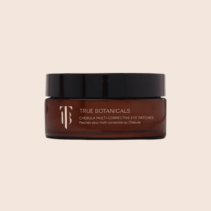 A brown jar labeled “True Botanicals Chebula Multi-Corrective Eye Patches” with a black lid, set against a plain beige background.