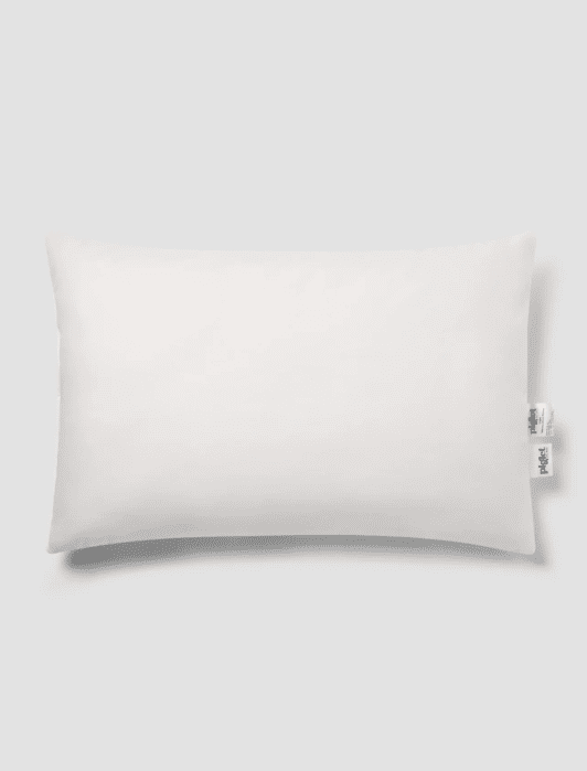 Rectangular white pillow with two tags on the right side, placed on a plain light gray background.