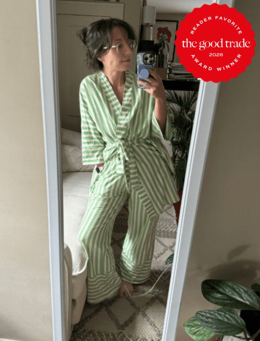 Person wearing green and white striped pajamas takes a mirror selfie in a bedroom. A “The Good Trade Reader Favorite Award Winner 2026” badge appears in the top right corner.