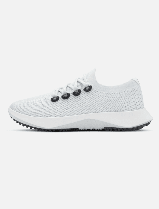A white athletic sneaker with a textured mesh upper, black eyelets, white laces, and a thick white sole with a gray tread, shown in a side profile view.