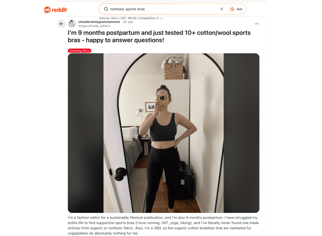 A woman stands in front of a mirror taking a selfie, wearing a black sports bra and black leggings, with text above about testing sports bras postpartum.