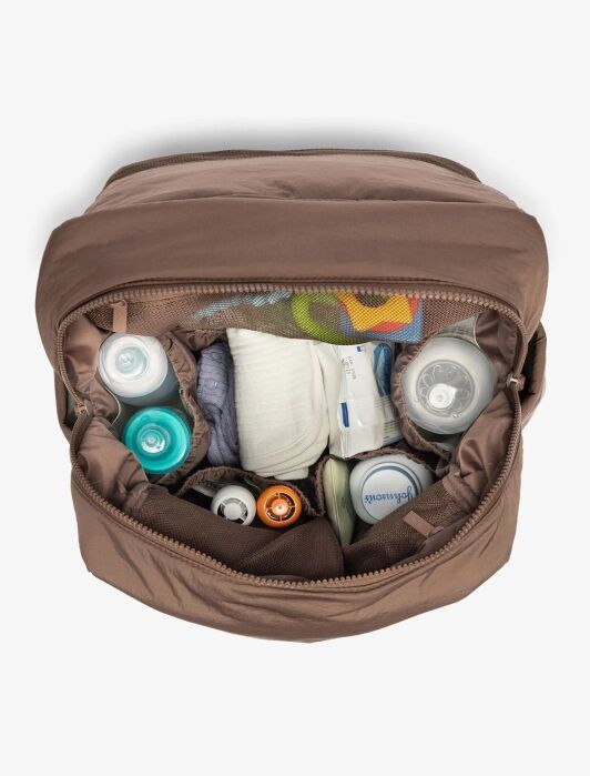 Open brown bag containing baby bottles, formula, a washcloth, a pacifier, and other baby care items, neatly organized in separate compartments.