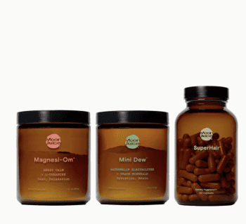 Three amber jars of Moon Juice supplements—Magnesi-Om, Mini Dew, and SuperHair—are displayed side by side on a white background.