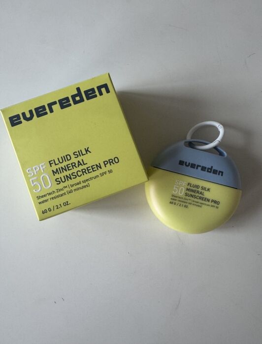 A box and bottle of Evereden SPF 50 Fluid Silk Mineral Sunscreen Pro are shown on a white surface.