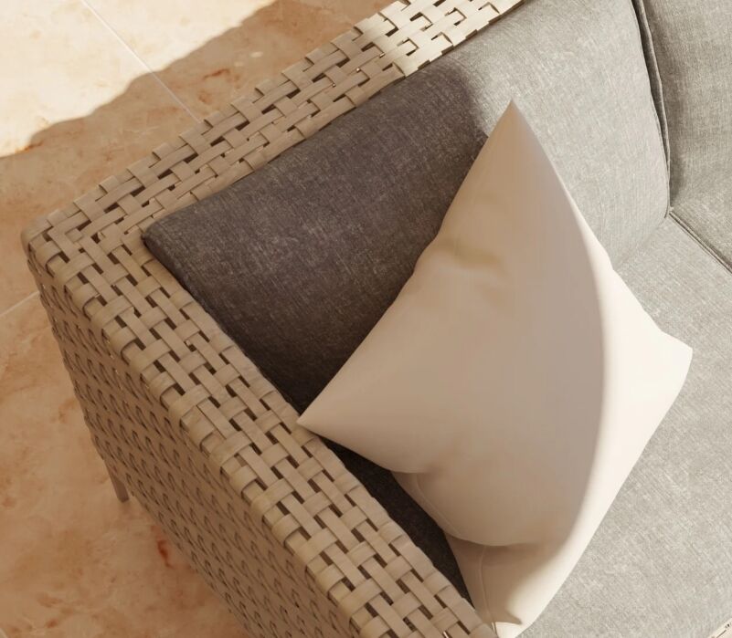 A beige woven outdoor sofa features a gray cushion and a white throw pillow, positioned on a light-colored tiled floor in sunlight.