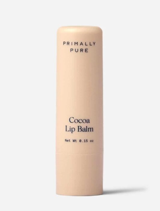 A beige tube of Primally Pure Cocoa Lip Balm, 0.15 oz, stands upright against a plain light background.