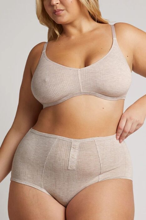 A woman wearing a beige ribbed bra and high-waisted underwear with button details poses against a plain background.