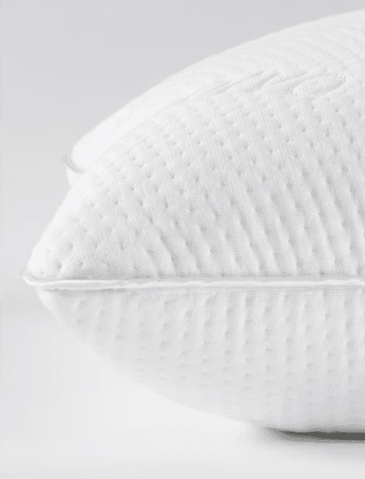 Side-by-side pillows: the left labeled “Standard Loft” is lower and the right labeled “High Loft” is higher, both with white textured covers on a plain background.