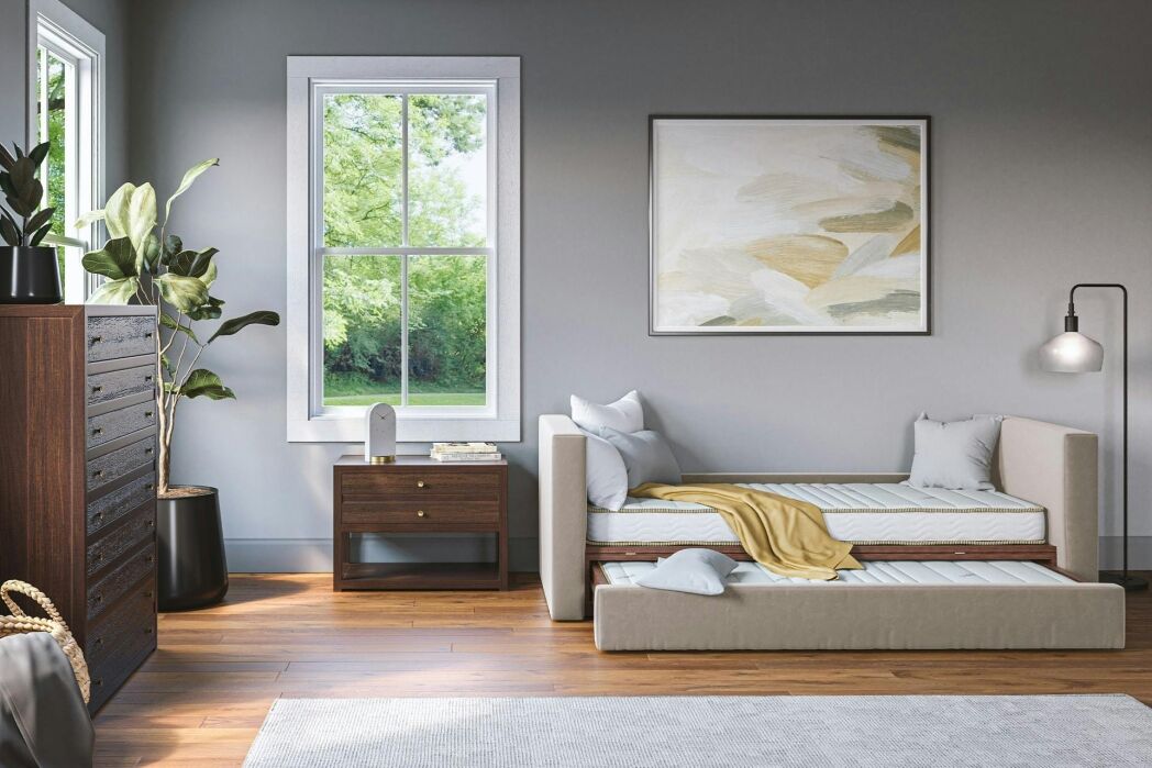 Modern bedroom with a twin trundle bed, wooden dresser, nightstand, potted plant, large window, and abstract wall art.