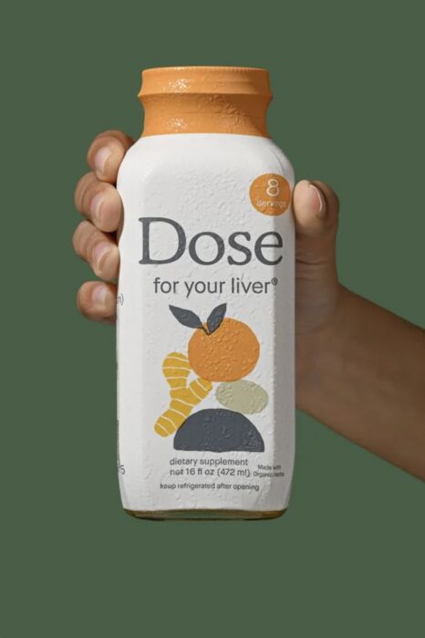 A hand holds a bottle labeled “Dose for your liver,” featuring fruit illustrations and stating 8 servings and dietary supplement.