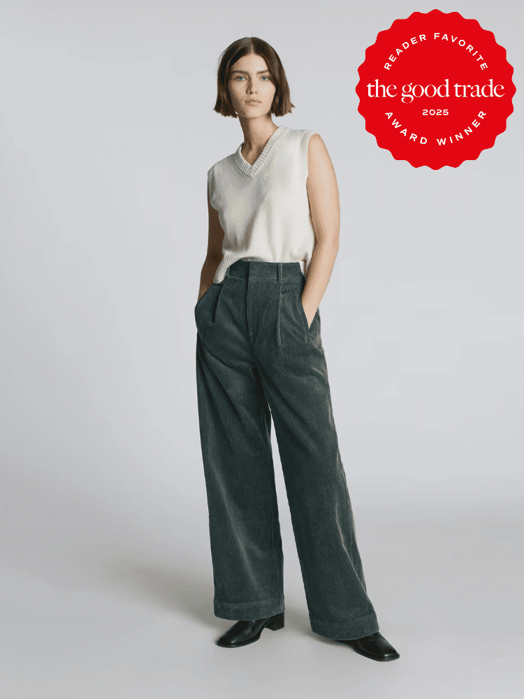 Person wearing a sleeveless white top and dark wide-leg pants, with hands in pockets. A red badge reads "Reader Favorite The Good Trade 2025 Award Winner" is on the upper right corner.